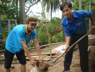 Chí Thảo (bìa trái) phụ hồ xây căn nhà mới do BGH, Đoàn Thanh niên trường xét hỗ trợ